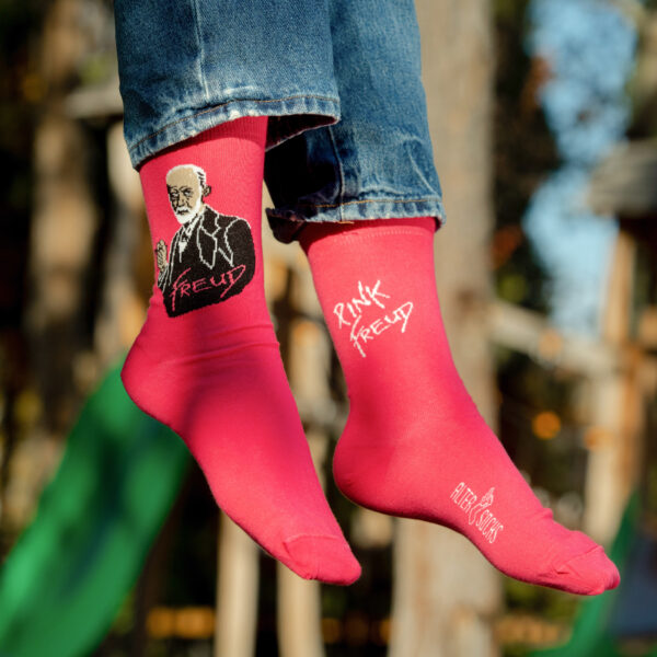 Accessoire mode, chaussettes Freud avec design original sur fond rose.