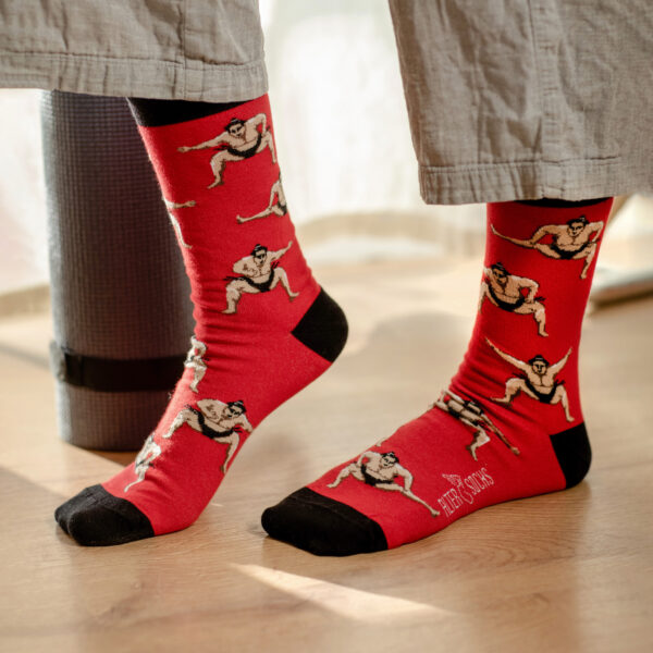 Chaussettes fantaisie aveChaussettes originales montrant des sumos sur fond rouge vifc design de sumos et fond rouge